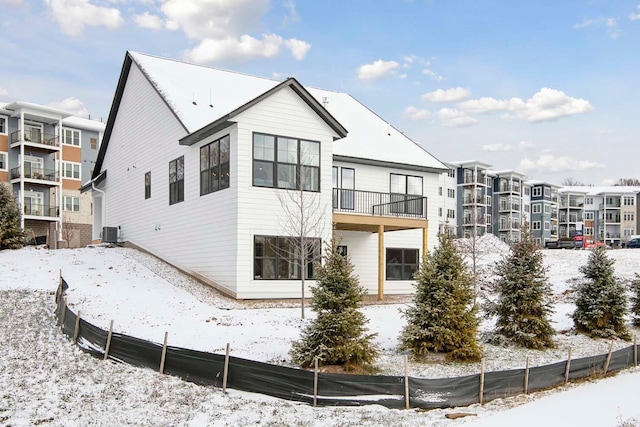 snow covered property with central air condition unit