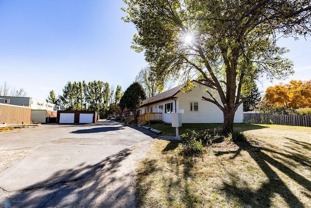 view of side of home featuring a garage and fence
