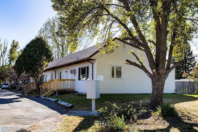 view of front of property featuring fence and roof with shingles