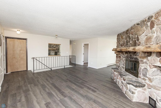 unfurnished living room featuring a fireplace, a textured ceiling, dark hardwood / wood-style flooring, and baseboard heating