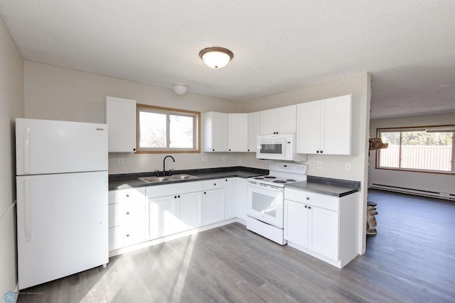 kitchen featuring wood finished floors, baseboard heating, a sink, and white appliances