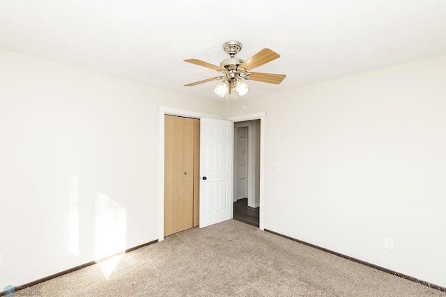 spare room with carpet, baseboards, and ceiling fan