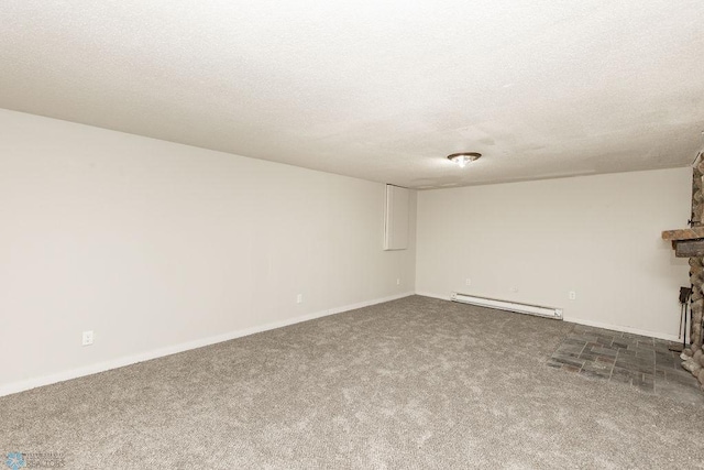 empty room featuring a fireplace, a textured ceiling, carpet flooring, and a baseboard heating unit