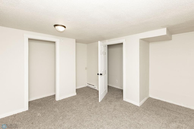 basement with baseboard heating, carpet floors, and a textured ceiling