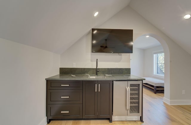 6620 Buckthorn Dr NW, Rochester, MN 55901 - indoor wet bar featuring beverage cooler, lofted ceiling, light wood finished floors, arched walkways, and recessed lighting