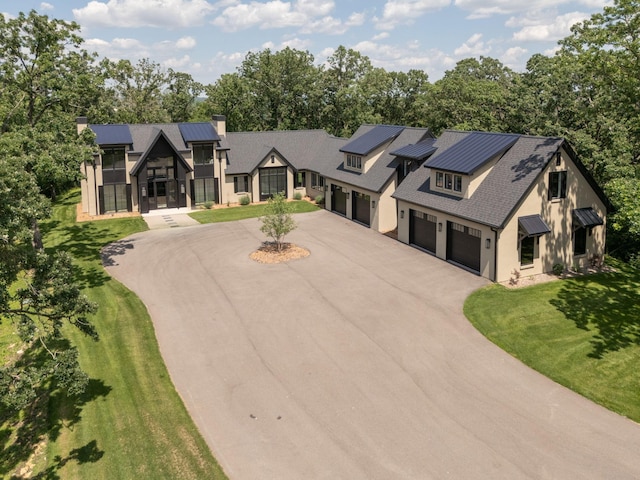 6620 Buckthorn Dr NW, Rochester, MN 55901 - modern farmhouse with curved driveway, a chimney, a front yard, view of scattered trees, and a standing seam roof