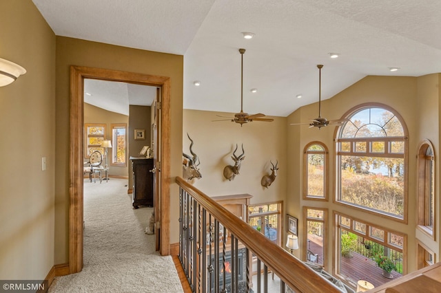 hall with lofted ceiling, light carpet, and a textured ceiling