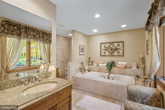 bathroom with vanity, tile patterned floors, and tiled bath