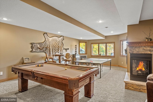 game room with a stone fireplace, a textured ceiling, light colored carpet, and billiards