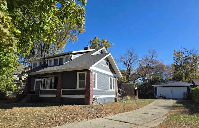 view of front of home with covered porch, a garage, and an outbuilding