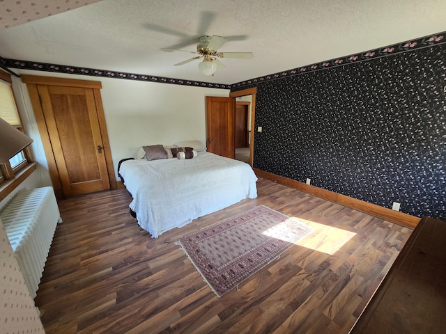 405 3rd Ave SE, Pipestone, MN 56164 - bedroom featuring wallpapered walls, radiator heating unit, wood finished floors, ceiling fan, and a textured ceiling