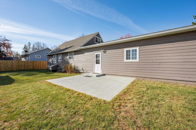 rear view of property featuring a yard and a patio area