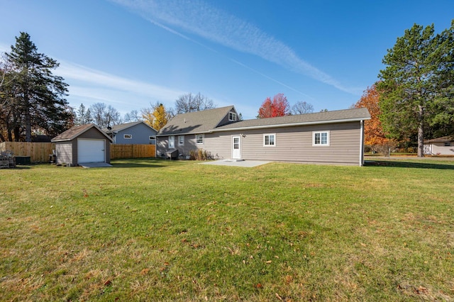 back of house with a patio, an outbuilding, a yard, and a garage