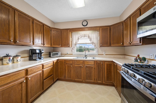 kitchen featuring appliances with stainless steel finishes, a textured ceiling, and sink