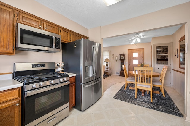 kitchen featuring ceiling fan, stainless steel appliances, and a textured ceiling