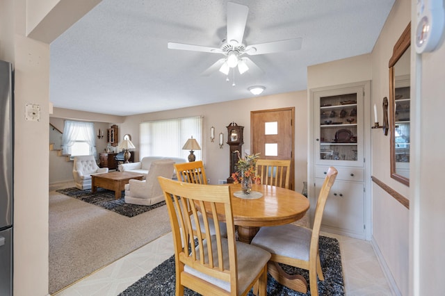 dining space with a textured ceiling and ceiling fan