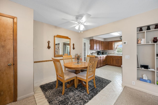 dining area featuring ceiling fan and a textured ceiling