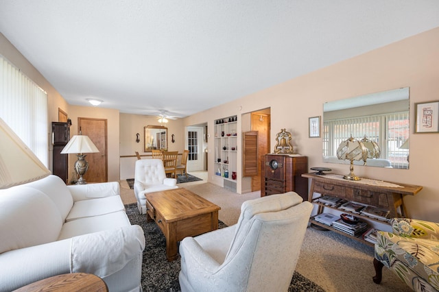 carpeted living room with ceiling fan