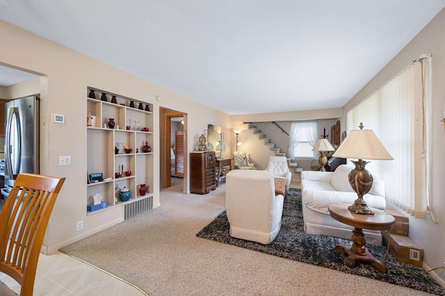 bedroom with stainless steel refrigerator and light colored carpet