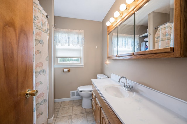 bathroom with toilet, a healthy amount of sunlight, vanity, and tile patterned floors