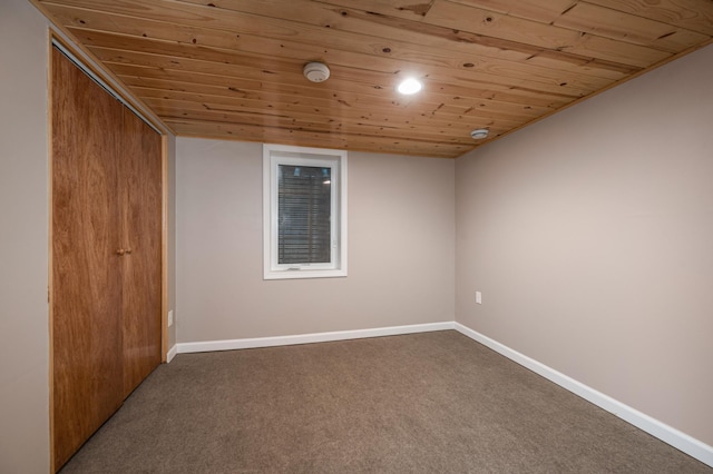 carpeted spare room with wood ceiling