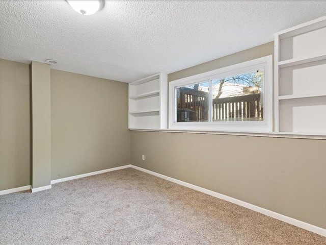 spare room with a textured ceiling and carpet floors