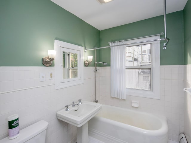 bathroom featuring baseboard heating, tile walls, and toilet