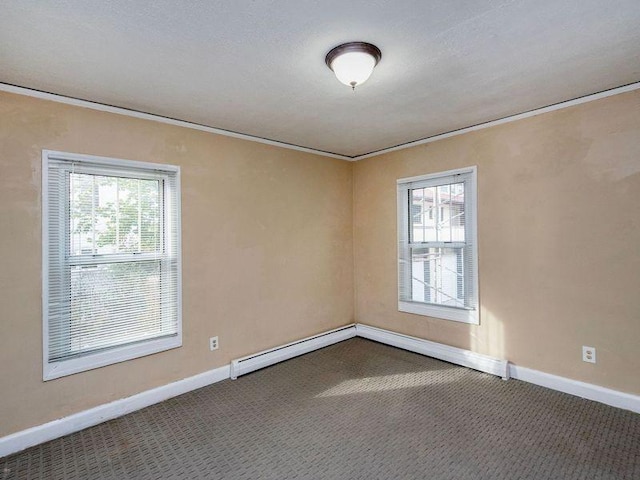 carpeted spare room with a textured ceiling and a baseboard heating unit