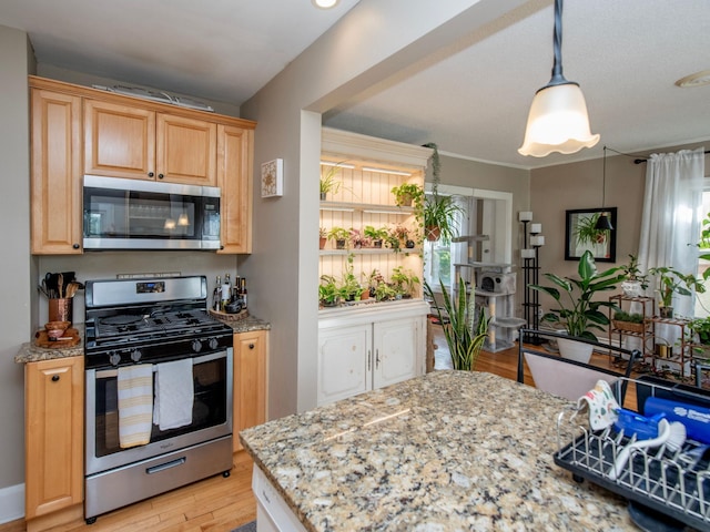 kitchen featuring light brown cabinets, hanging light fixtures, appliances with stainless steel finishes, light wood-type flooring, and light stone counters