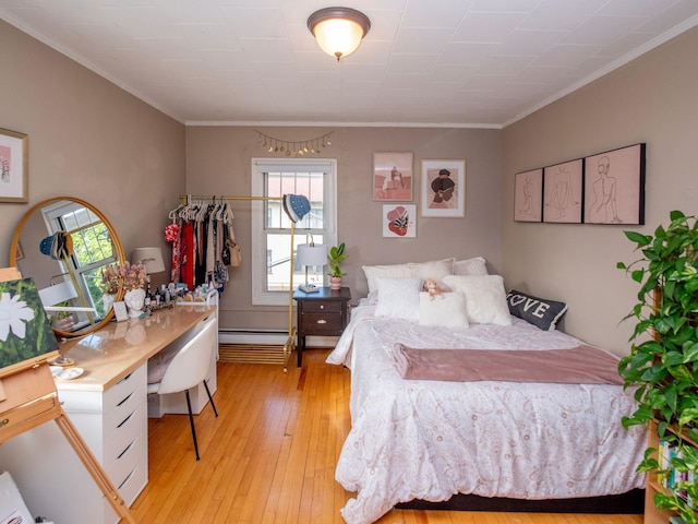 bedroom featuring crown molding, baseboard heating, and light wood-type flooring