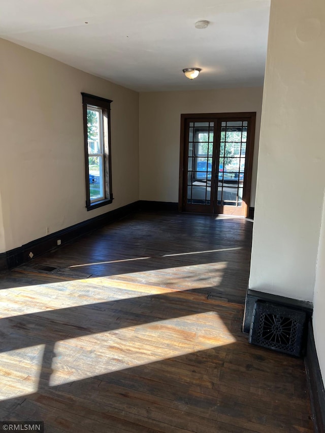 spare room featuring french doors and dark hardwood / wood-style floors