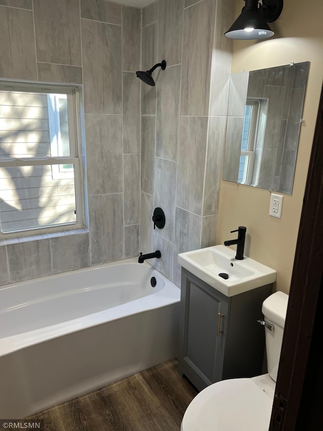 full bathroom featuring bathing tub / shower combination, hardwood / wood-style floors, vanity, and toilet