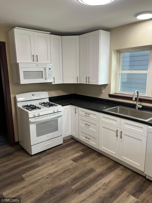 kitchen featuring white appliances, dark hardwood / wood-style floors, white cabinetry, and sink