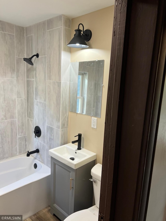 full bathroom featuring vanity, toilet, and tiled shower / bath combo