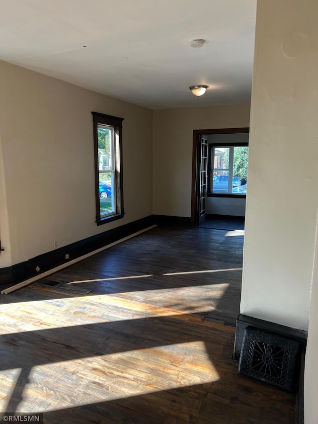 empty room featuring dark hardwood / wood-style floors and a healthy amount of sunlight