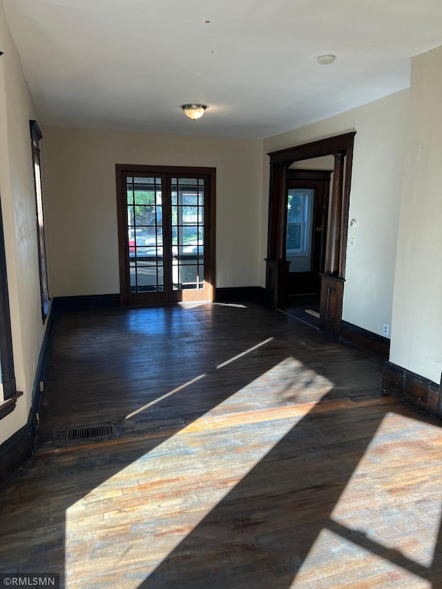 spare room with dark hardwood / wood-style flooring and french doors