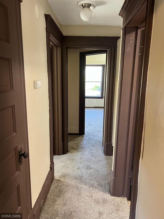 hall with light colored carpet