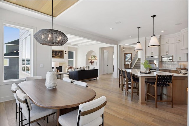 dining area featuring light hardwood / wood-style floors and beam ceiling