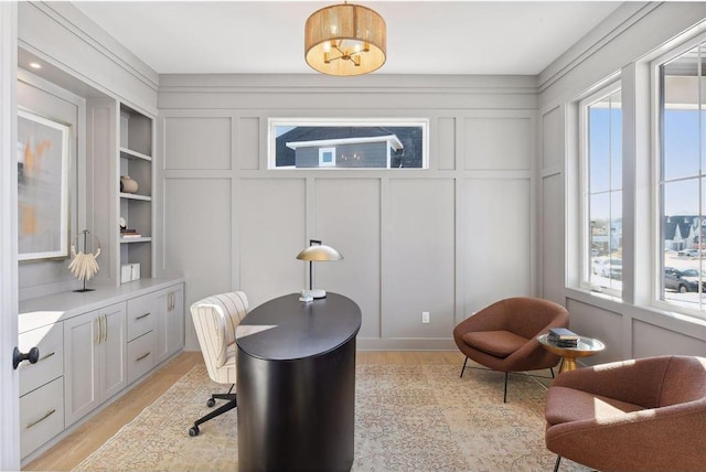 office featuring built in features and light wood-type flooring