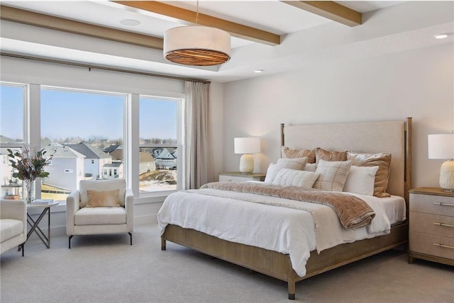 bedroom featuring beamed ceiling and light colored carpet