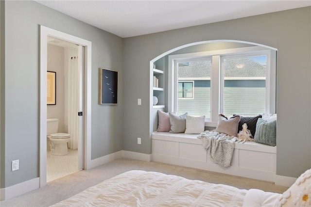 bedroom featuring light carpet and ensuite bathroom