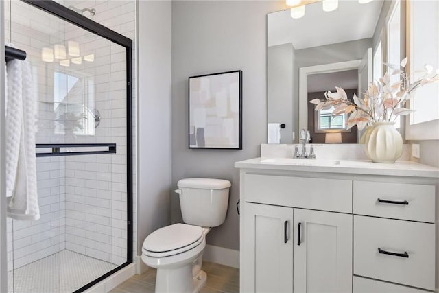 bathroom with vanity, a shower with shower door, and toilet