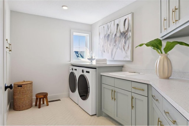 laundry area featuring independent washer and dryer and cabinets