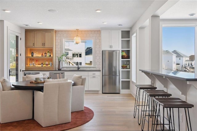 dining area featuring sink, a textured ceiling, and light hardwood / wood-style flooring