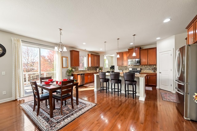 dining room featuring sink, dark wood-type flooring, and an inviting chandelier