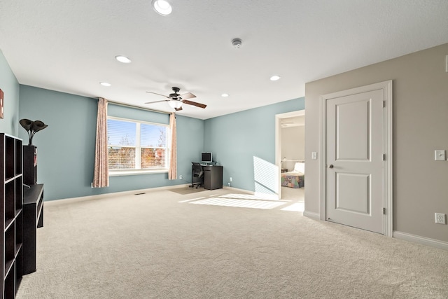 interior space featuring ceiling fan and light colored carpet