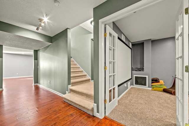 stairs featuring a textured ceiling and hardwood / wood-style flooring