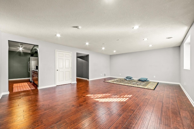 interior space featuring a textured ceiling and dark wood-type flooring