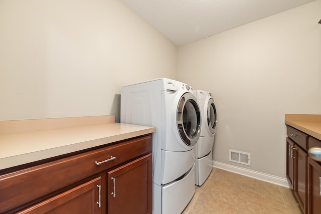 laundry room featuring cabinets and washing machine and clothes dryer