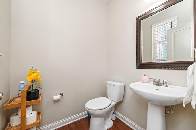 bathroom with hardwood / wood-style flooring and toilet